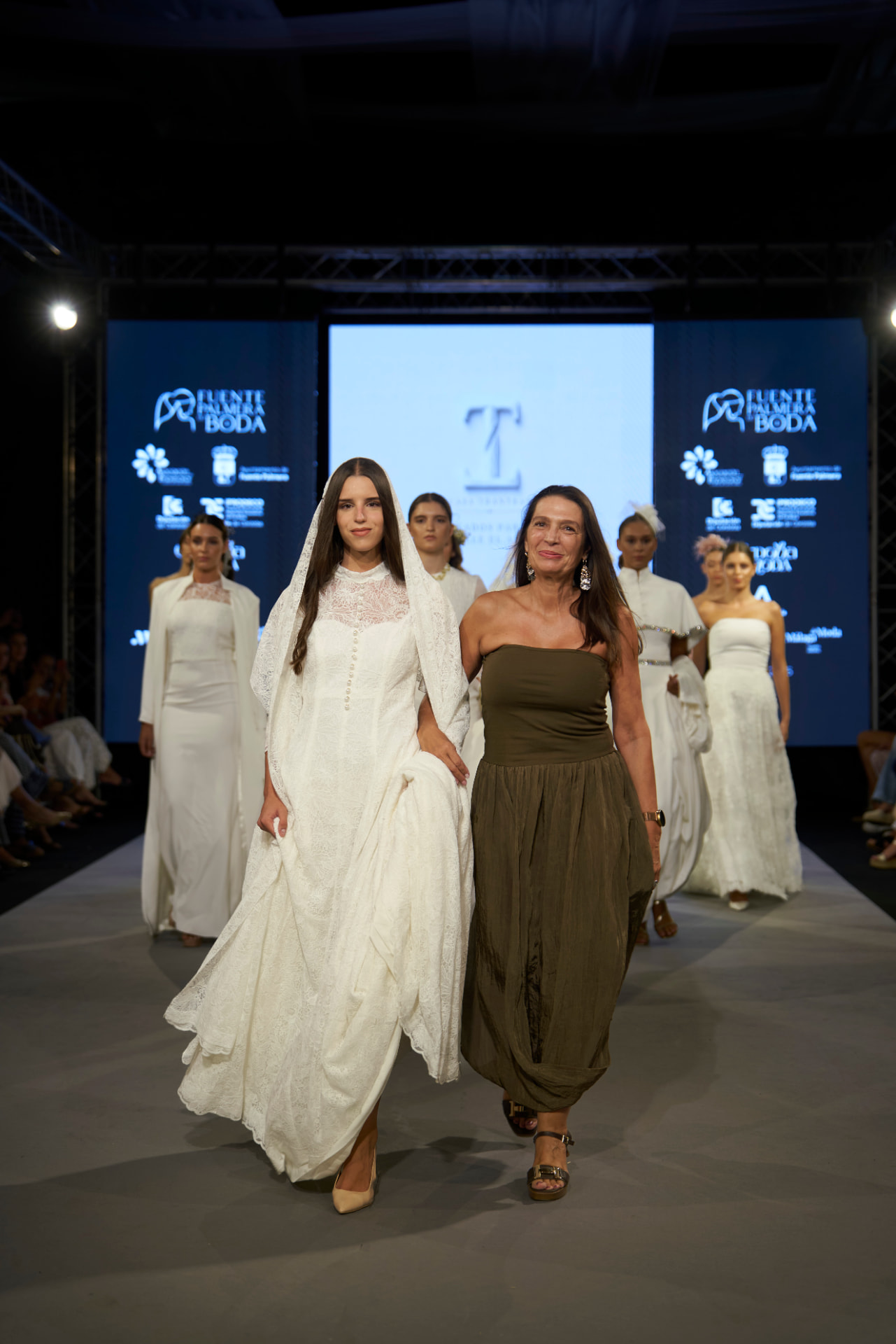 La diseñadora acompaña a la novia en el pase final del desfile