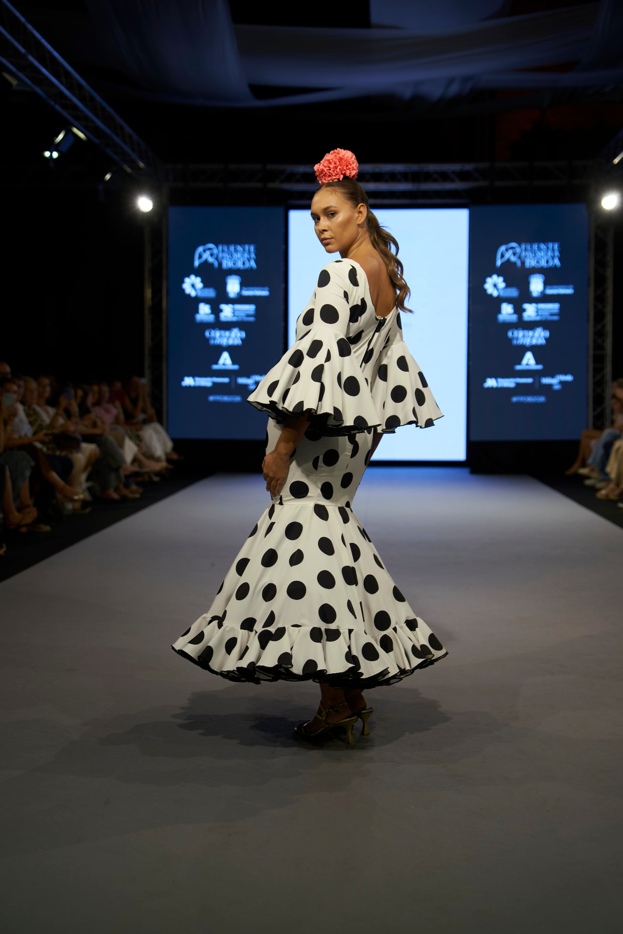 Traje de flamenca blanco de lunares negros, modelo girada mirando atrás