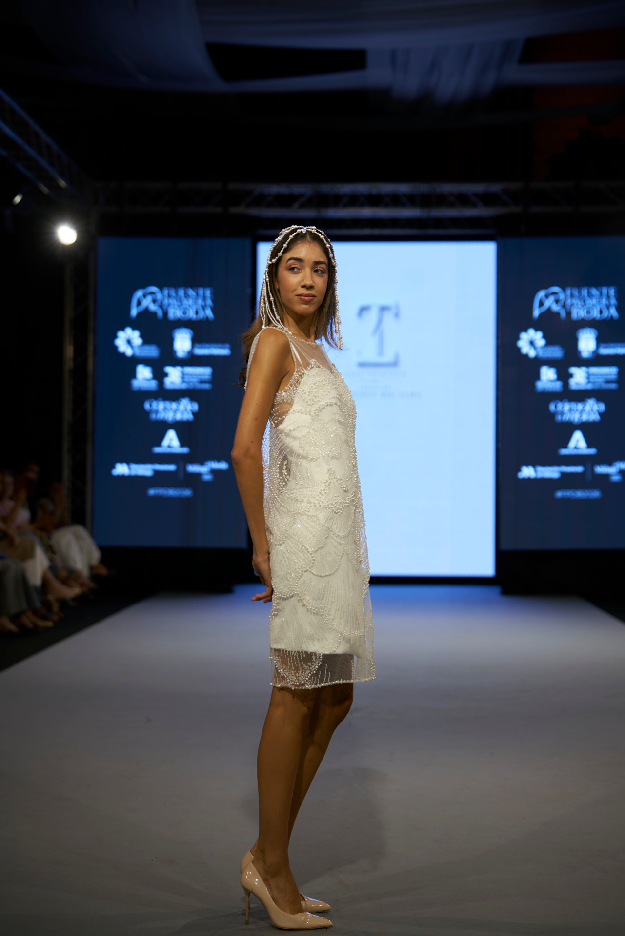 Vestido corto bordado con perlas e incrustaciones brillantes, de perfil