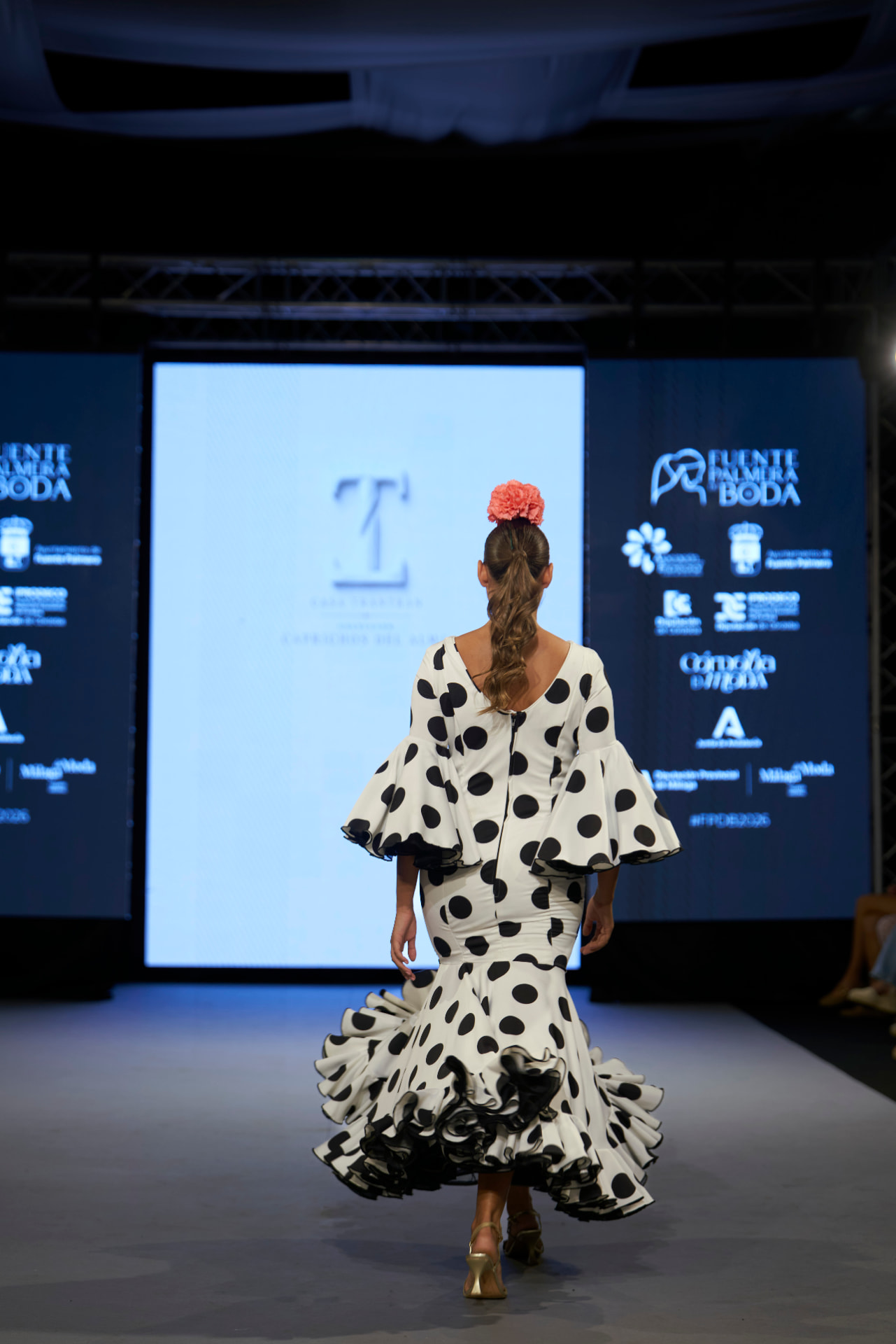 Traje de flamenca de lunares negros con escote en la espalda, de espaldas
