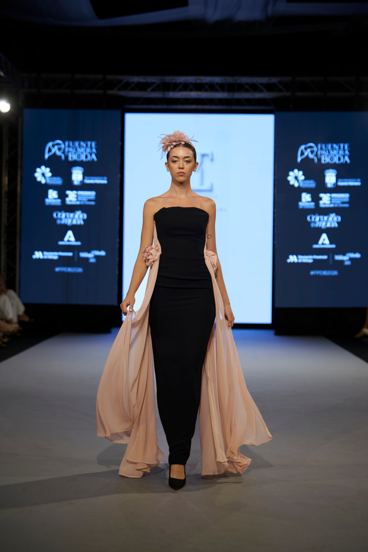 Vestido negro palabra de honor con sobrefalda de gasa rosa empolvado, de frente