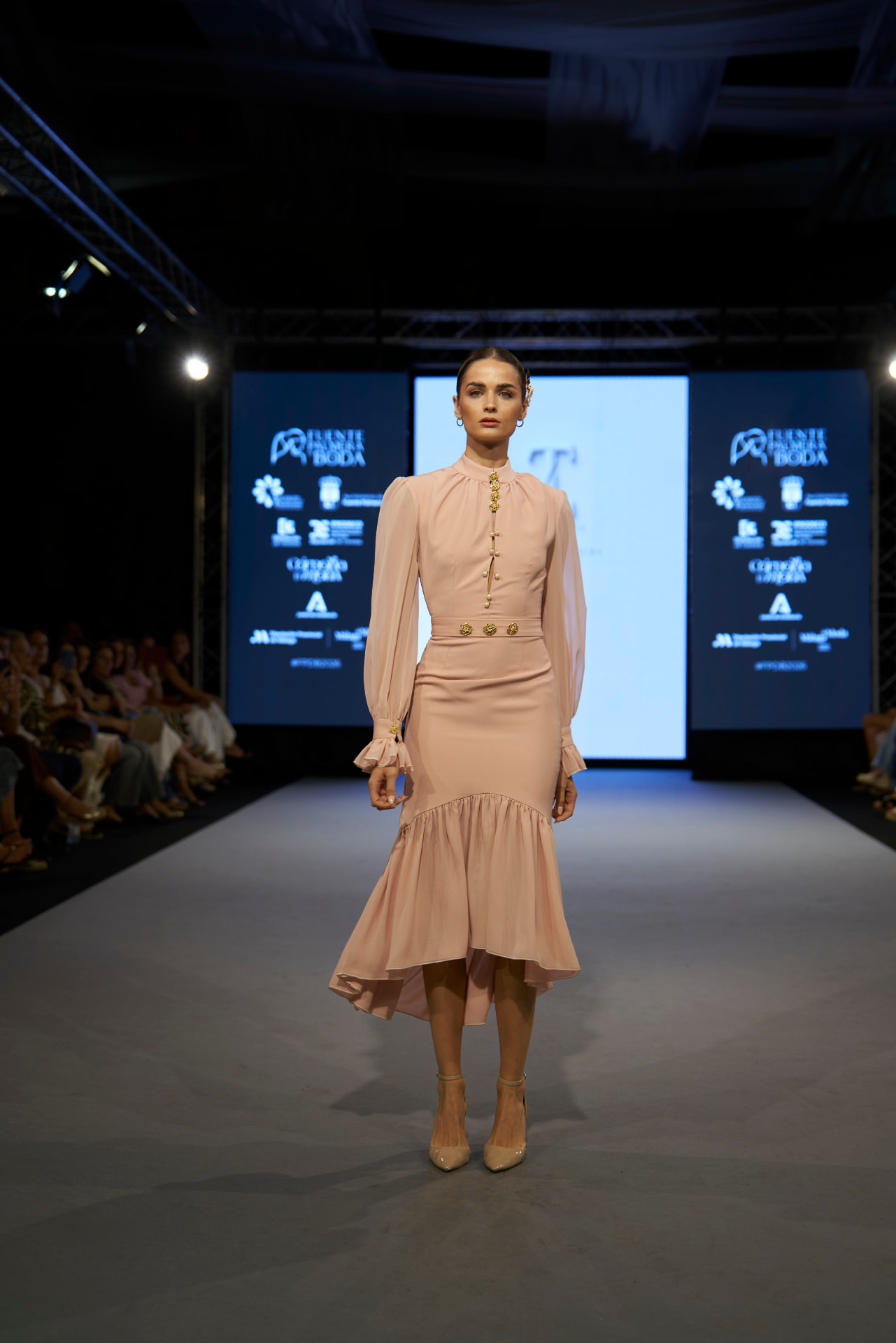 Vestido rosa empolvado de mangas de gasa y botonadura dorada, de frente