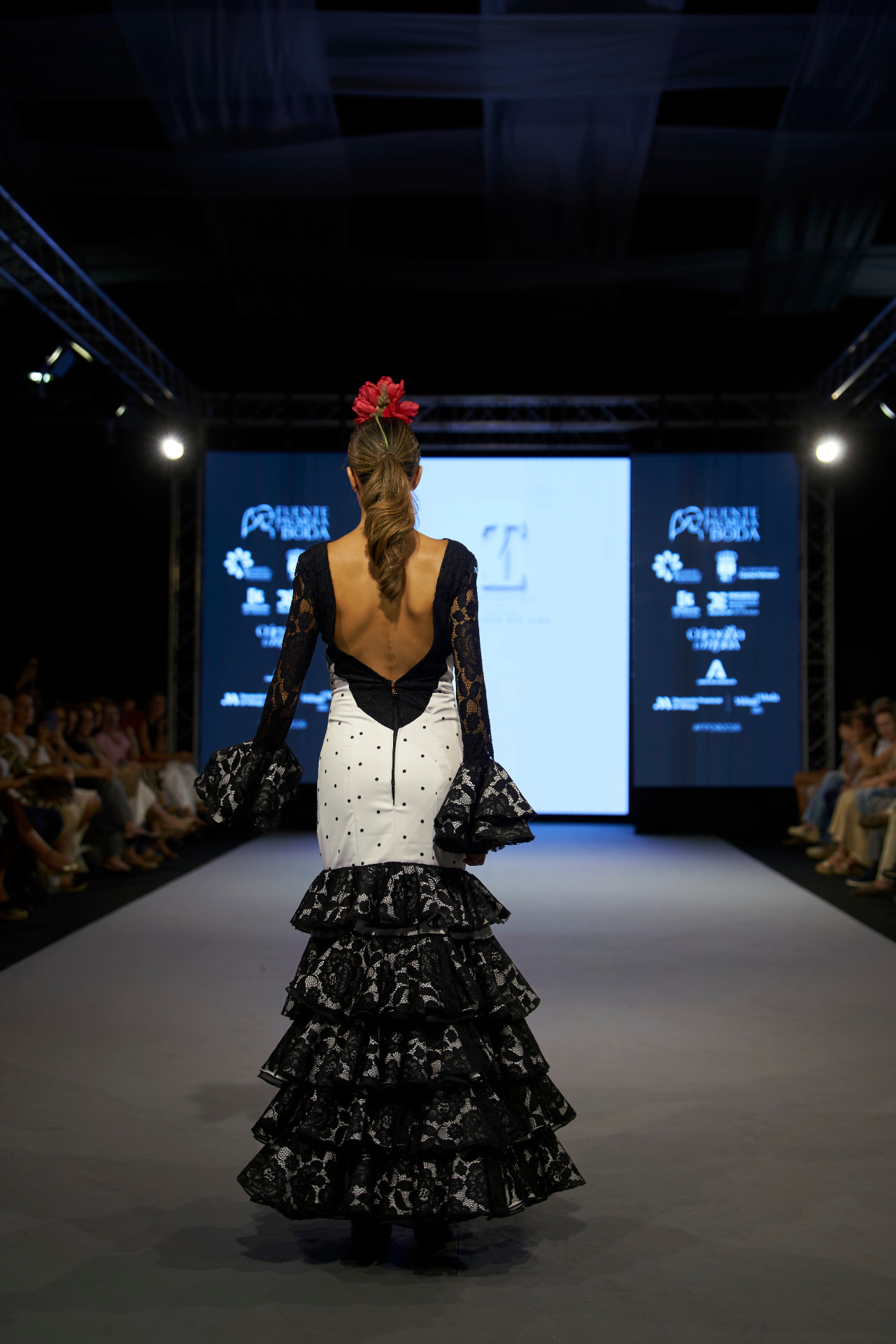 Traje de flamenca con escote en la espalda y volantes de encaje negro, de espaldas