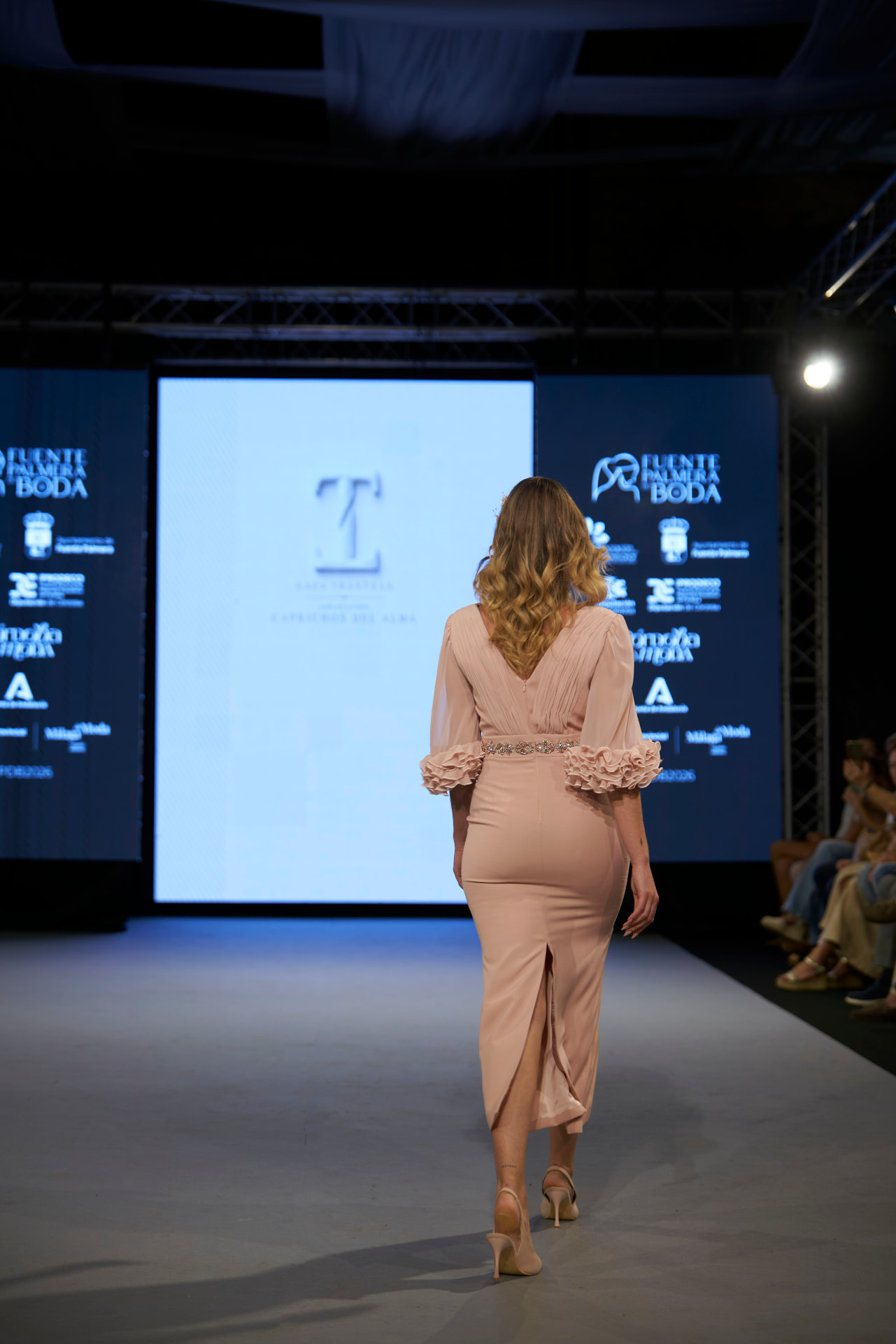 Vestido rosa con cinturón joya y puños de volantes, de espaldas