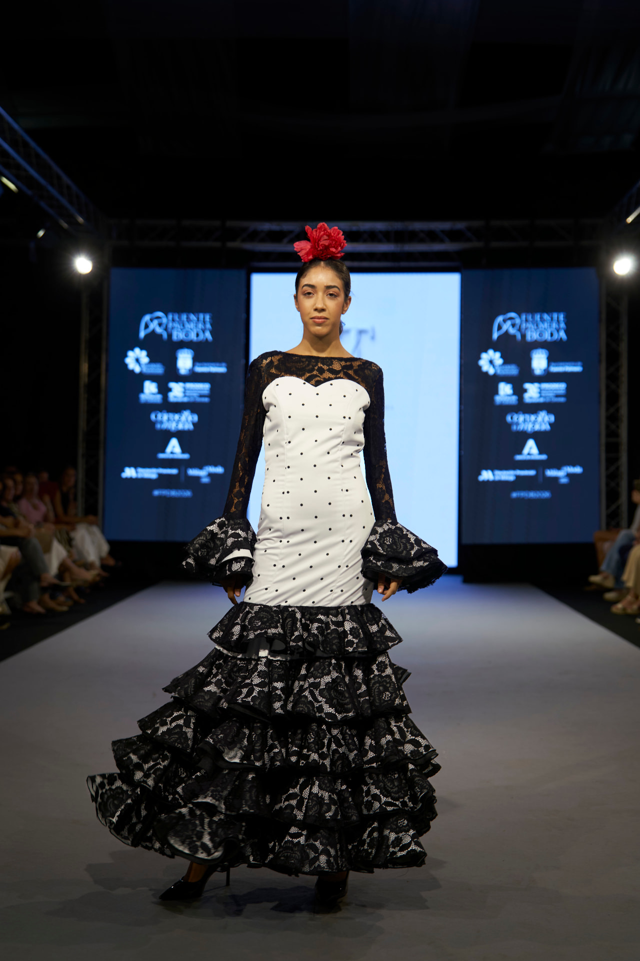 Traje de flamenca blanco de lunares con mangas y volantes de encaje negro, de frente