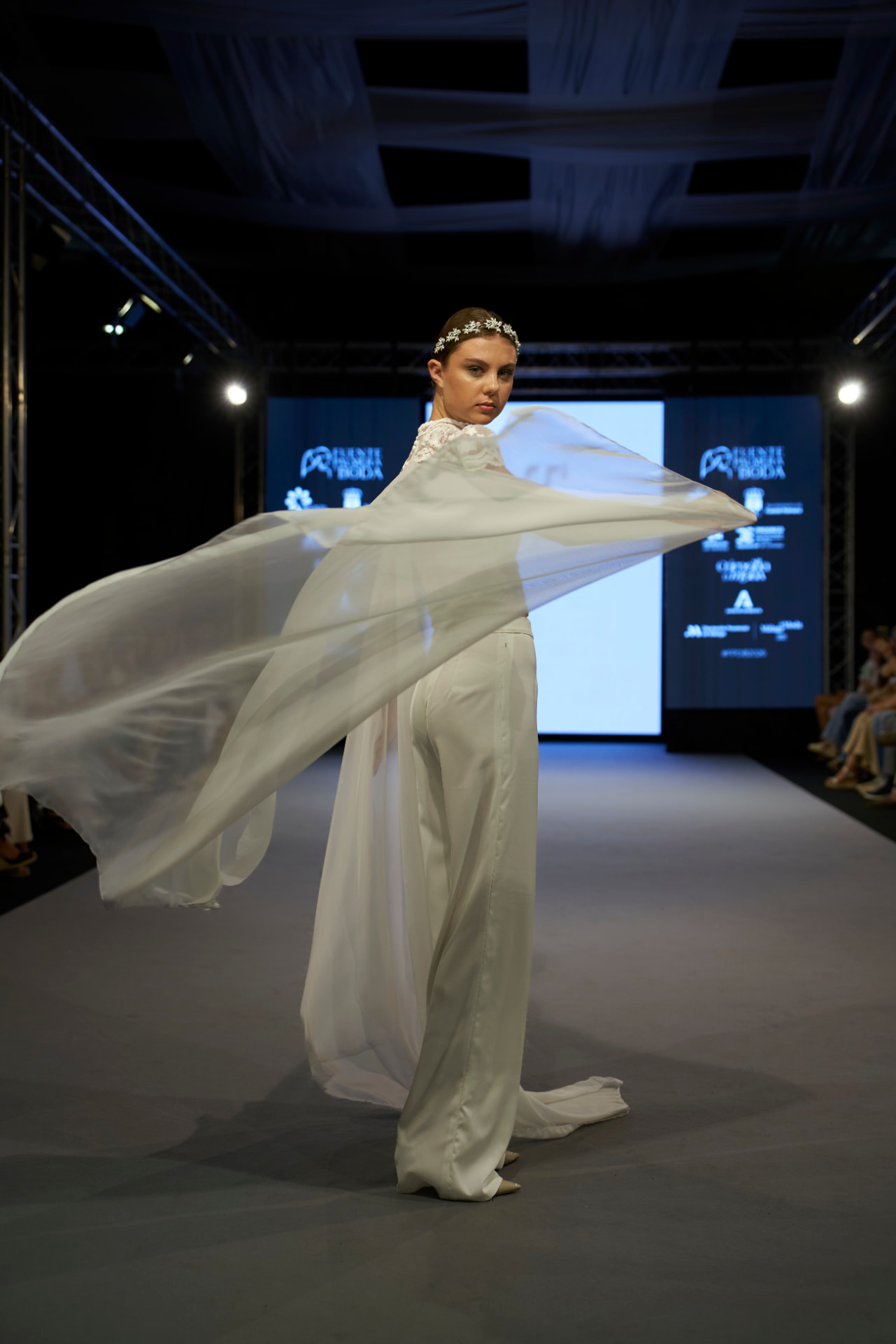 Capa vaporosa en movimiento sobre pantalón palazzo blanco