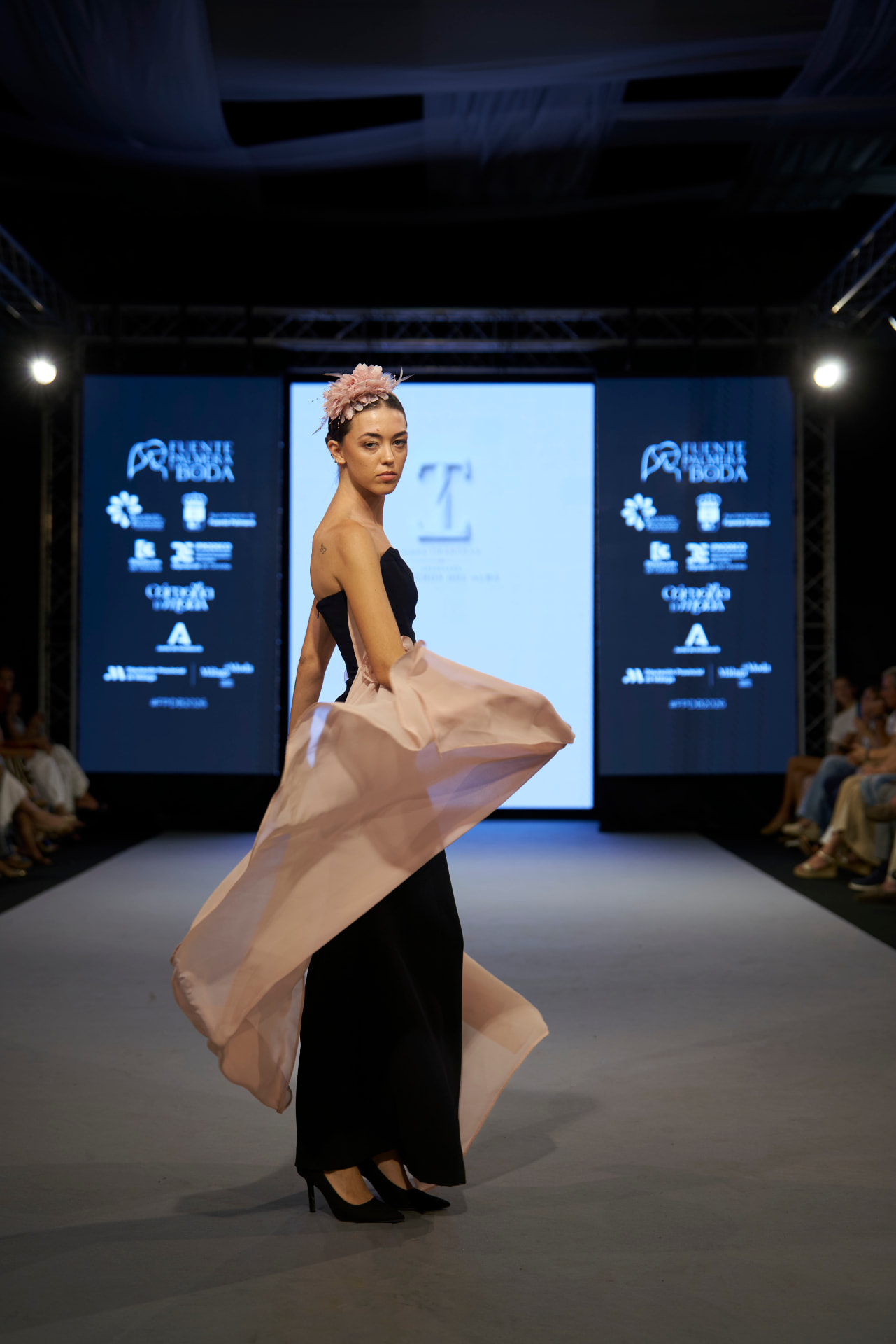 Vestido negro ceñido con capa de gasa rosa en movimiento, de tres cuartos